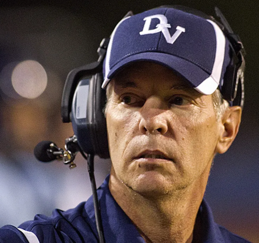 Close-up of Joe Kersting on the sideline in a team cap and headset.